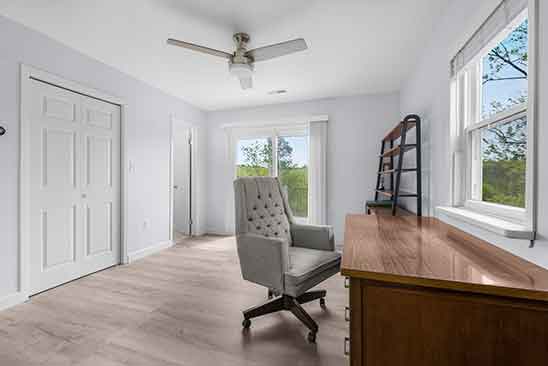 Bright home office or bedroom at 1701 Harrington Road, Orange VA, with large windows, built-in closet, ceiling fan, and sliding glass doors to outside.