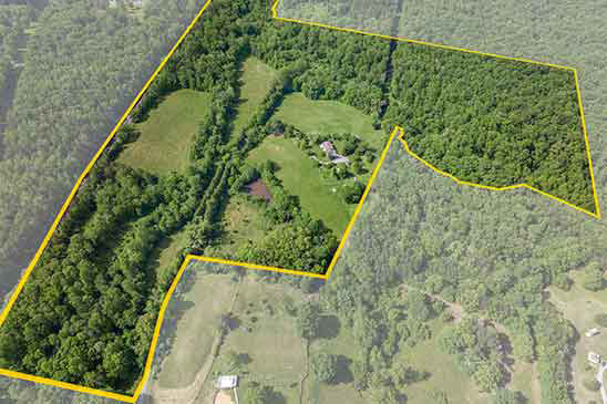 Aerial view of 66.52-acre property at 1701 Harrington Road, Orange VA, outlined in yellow, showing open pasture, wooded acreage, farmhouse, and private pond at 1701 Harrington Rd, Gordonsville VA.