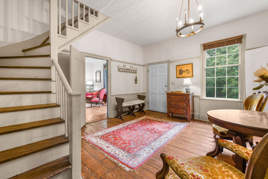 Entry hall at 3665 Old River Trail, Powhatan, VA—a gracious introduction to this historic home, featuring original wide-plank pine floors, hand-planed woodwork, and a classic side-passage staircase.
