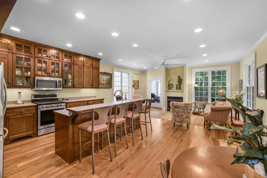 Kitchen and family room at 3665 Old River Trail in Powhatan, Virginia, featuring custom cabinetry, stainless steel appliances, and an open layout. Part of the 2001 addition at Pleasant Oak, this bright space blends modern comfort with historic charm and opens to a screened porch overlooking the gardens.
