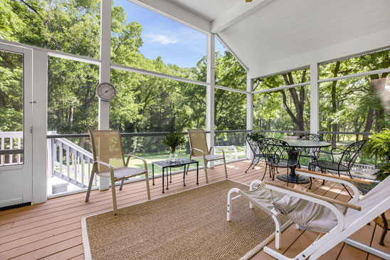 Screened porch at 3665 Old River Trail in Powhatan, Virginia, featuring wooded views, outdoor seating, and space for dining. This tranquil retreat connects to the family room at Pleasant Oak and overlooks the private backyard.