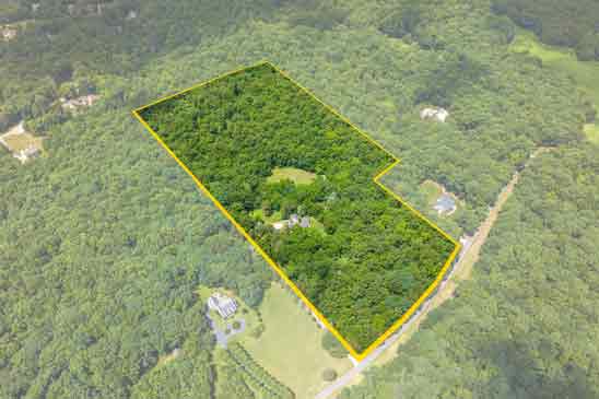 Aerial view of Pleasant Oak’s 26.18-acre retreat—a hidden gem nestled within a wooded canopy along one of Powhatan’s most scenic byway at 3665 Old River Trail in Powatan. 
