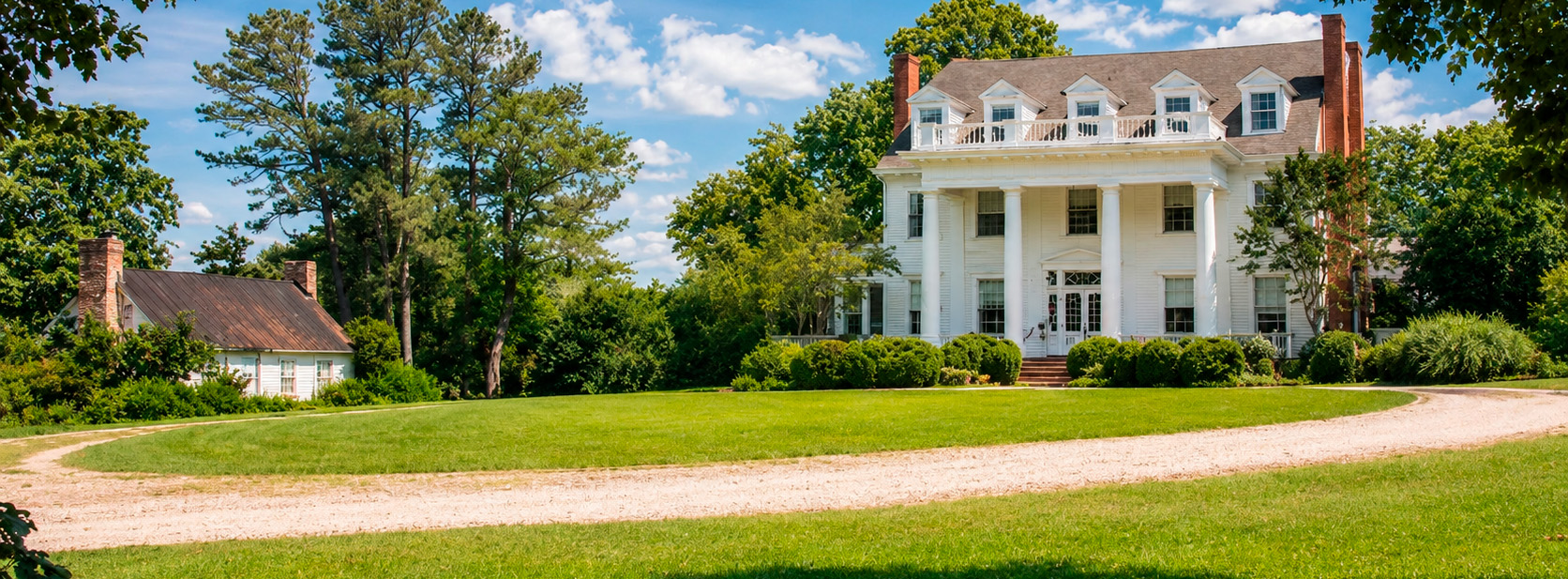 Luxury historic home in Central Virginia with grand columned facade, sweeping circular drive, manicured grounds, and timeless estate architecture
